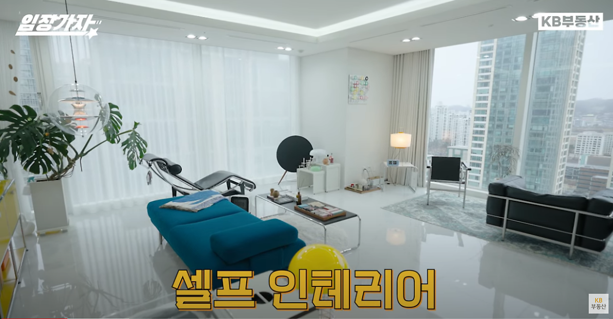 흰색 벽지와 바닥을 배경으로 '시티뷰'가 보이는 깔끔한 '거실'의 모습이다.