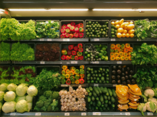 식료품 점의 채소 코너를 촬영한 사진. 파프리카, 배추, 브로콜리 등 다양한 종류의 채소들이 보인다.
