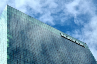'네이버' 본사 건물의 상단 부분을 촬영한 사진이다. 건물 외관은 유리로 되어 있으며, 초록색을 띄고 있다.
