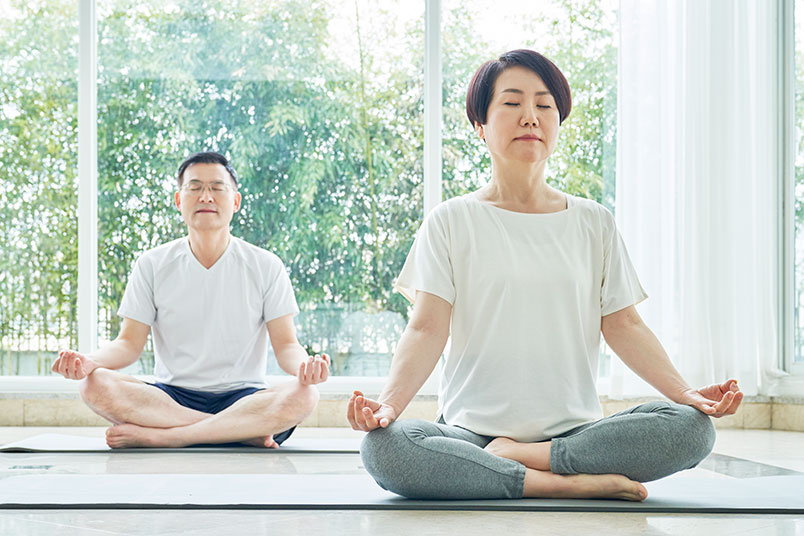 요가 매트위에서 두 사람이 '명상'을 하고 있는 모습이다.