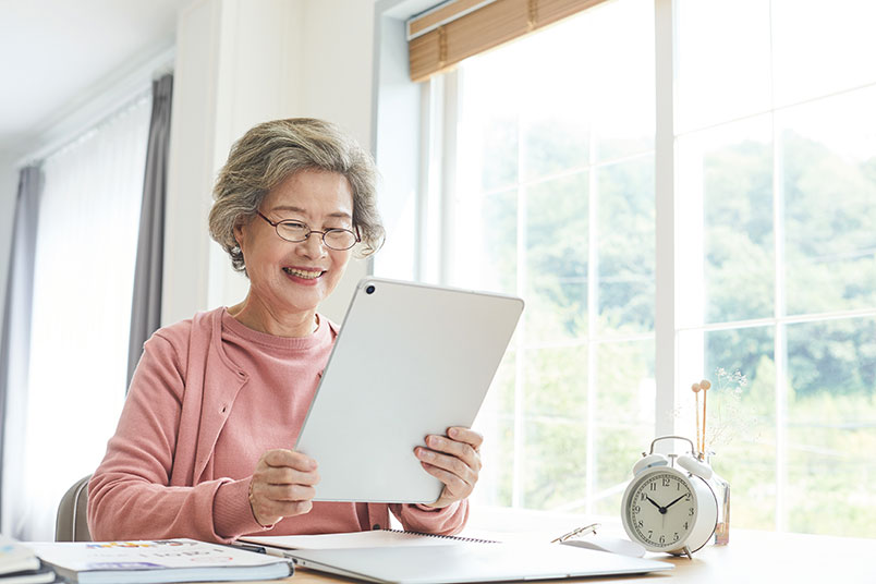 한 노년의 여성이 '테블릿 PC'를 보며 웃고 있는 모습이다.