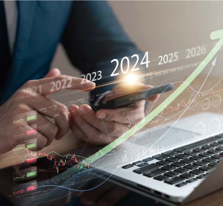 한 남자가 노트북과 스마트폰을 통해 '2024년' '주식시장'을 예측하는 모습이다.