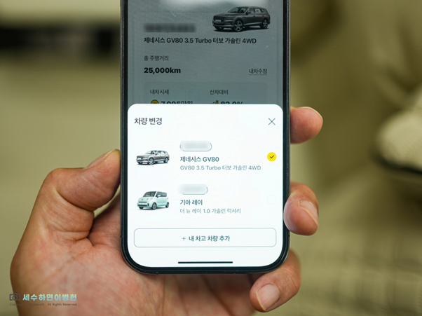 왼손으로 스마트폰을 들고 'KB차차차' 앱의 '내차고 등록' 서비스를 보여주는 이미지. 차량 번호와 실소유자 이름 입력을 통해 사용 가능.