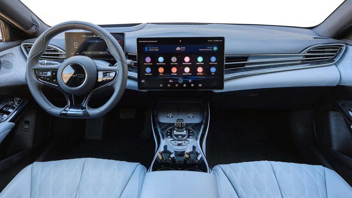 BYD 씰 차량 내부 디스플레이어와 핸들, '흰색' 시트가 있는 '운전석' 이미지이다.