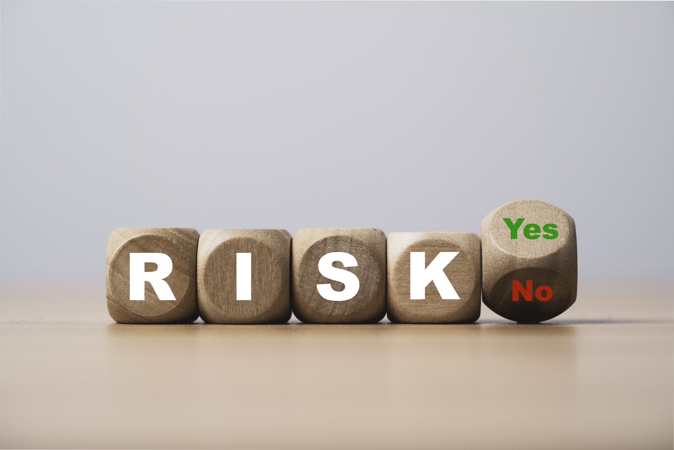 리스크를 표현한 이미지로 나무 블록에 RISK 글씨와 YES NO 글씨가 하나씩 적혀있다.