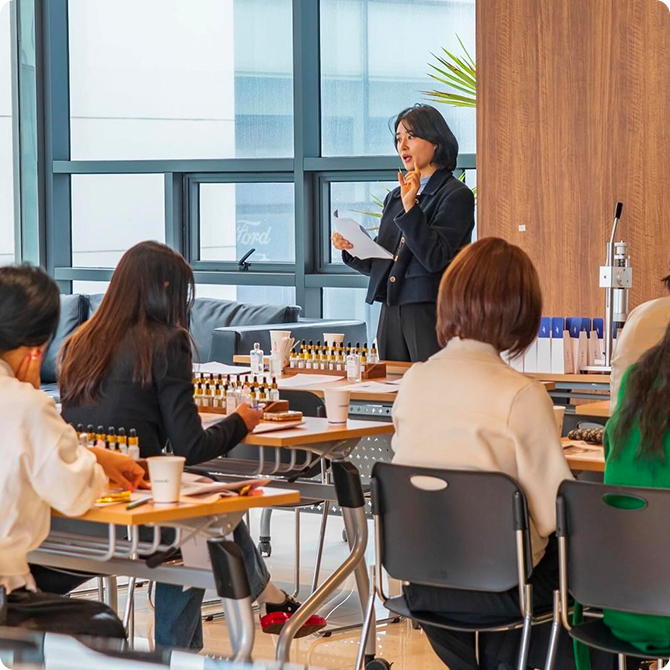 에드유 기업 및 기관 단체 강의. 강연을 하는 전희정 대표와 수업에 참여하는 사람들의 뒷모습이 보인다.